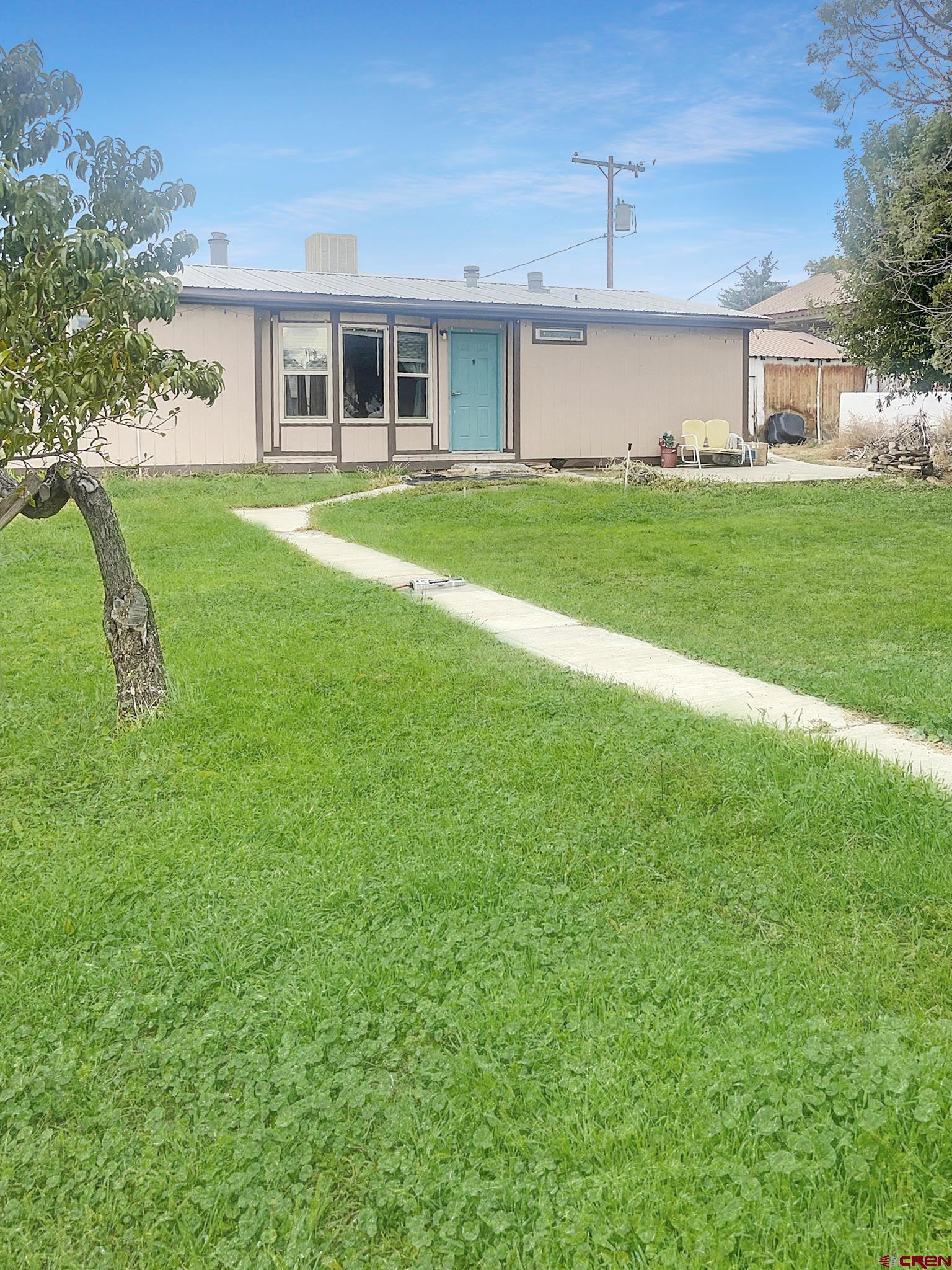 a front view of a house with a yard and trees