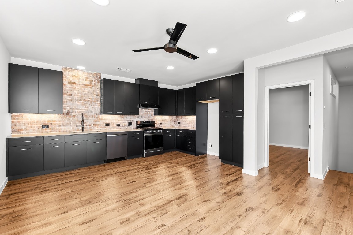 a kitchen with stainless steel appliances kitchen island granite countertop a sink and cabinets