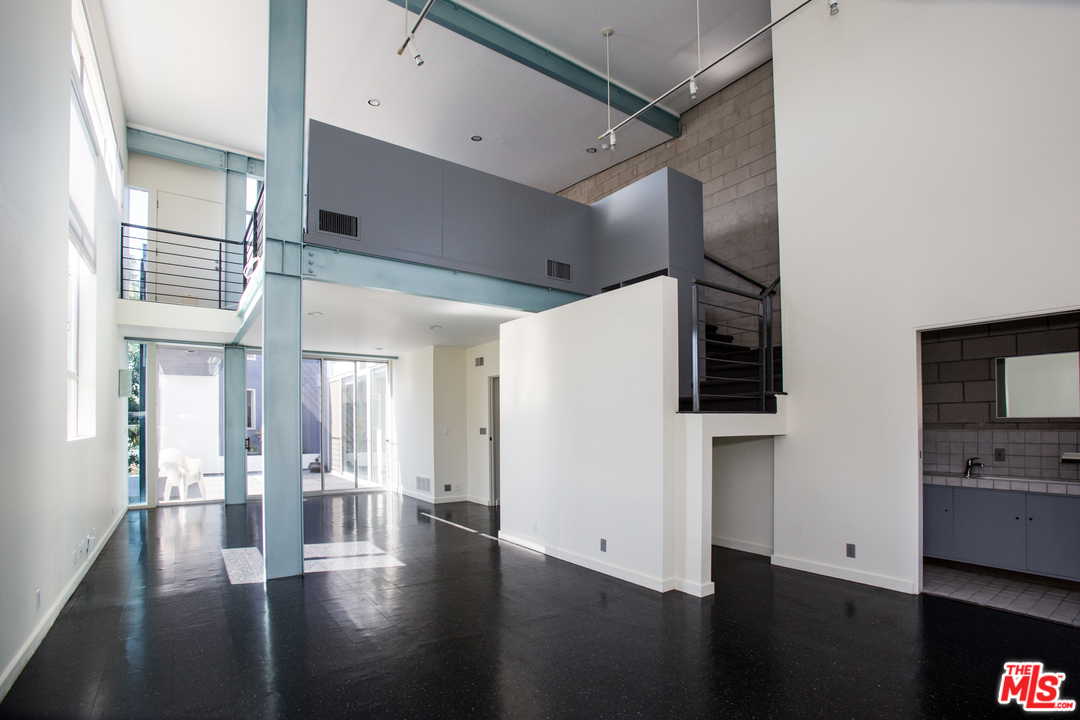 a view of a hallway with wooden floor and cabinets