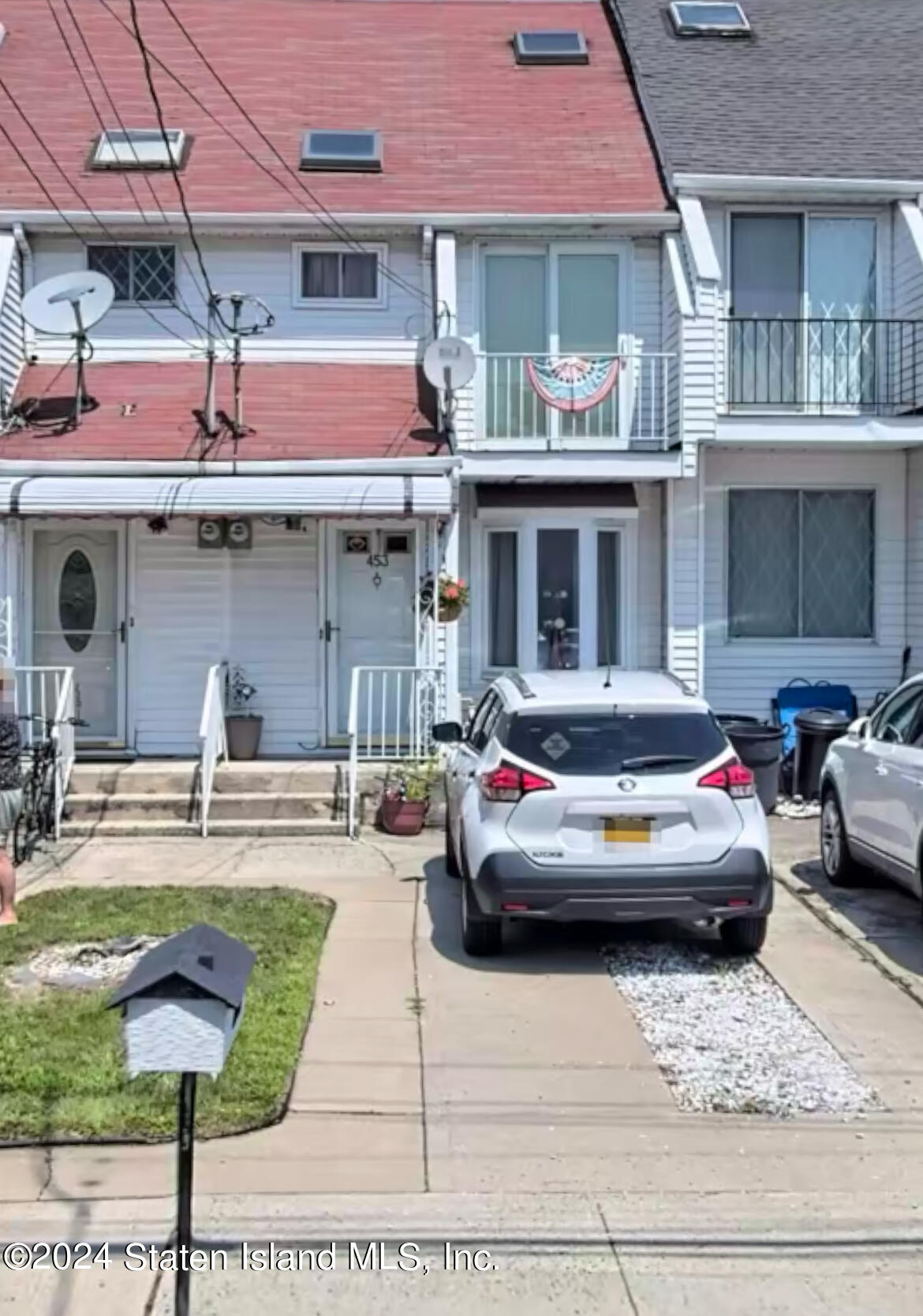 a front view of a house with car parked