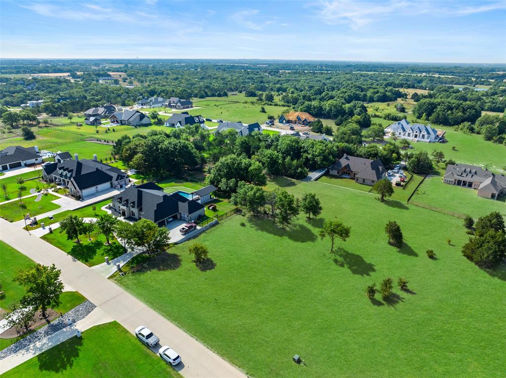 an aerial view of residential houses with outdoor space and trees