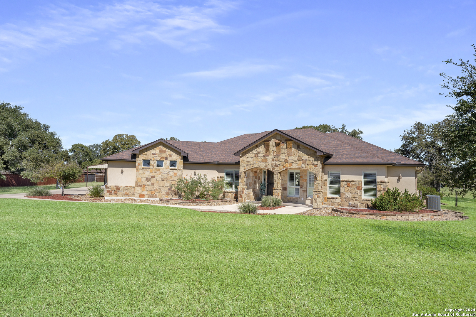 a front view of a house with a yard and trees