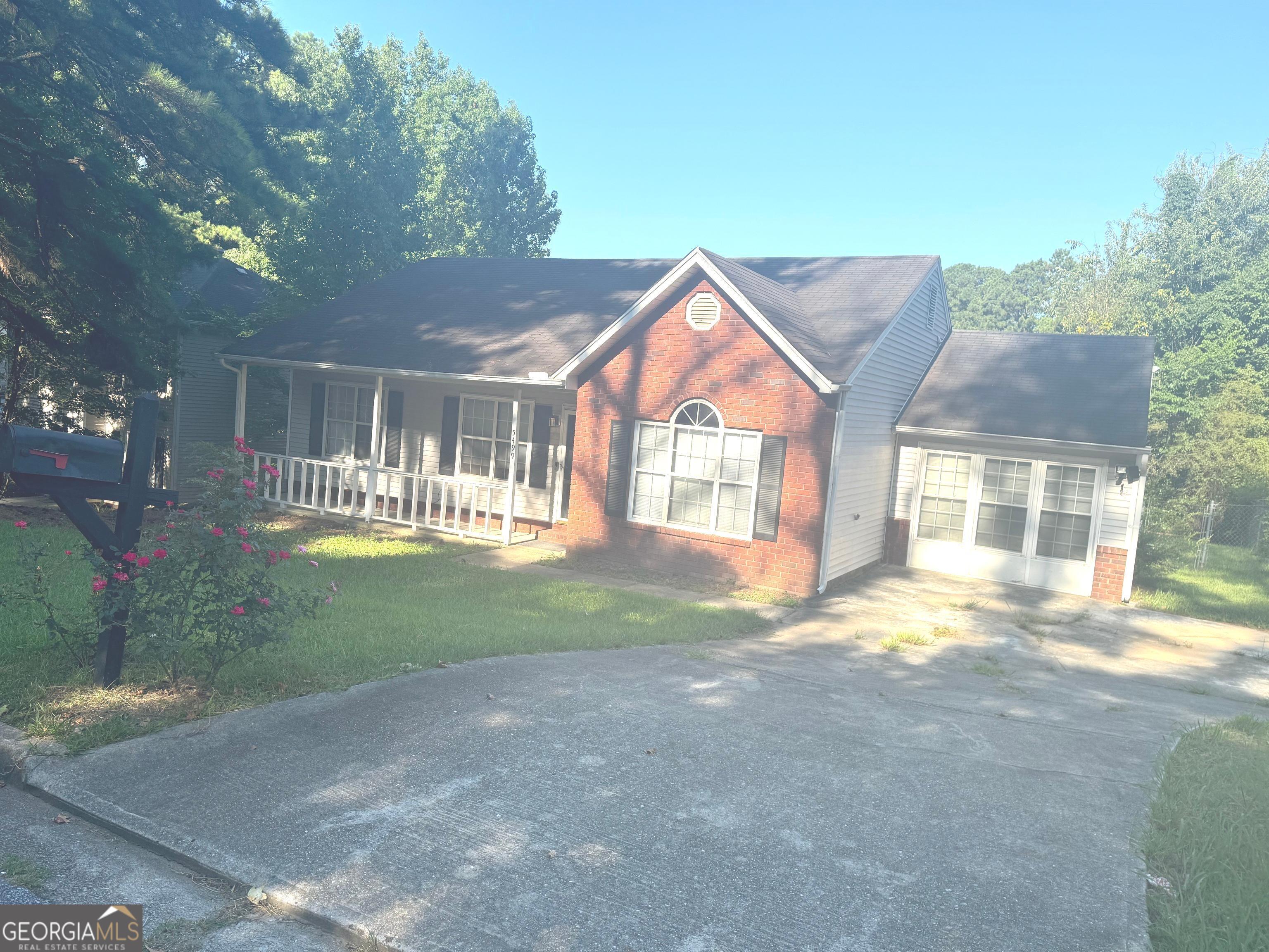 a view of a house with a yard and large trees