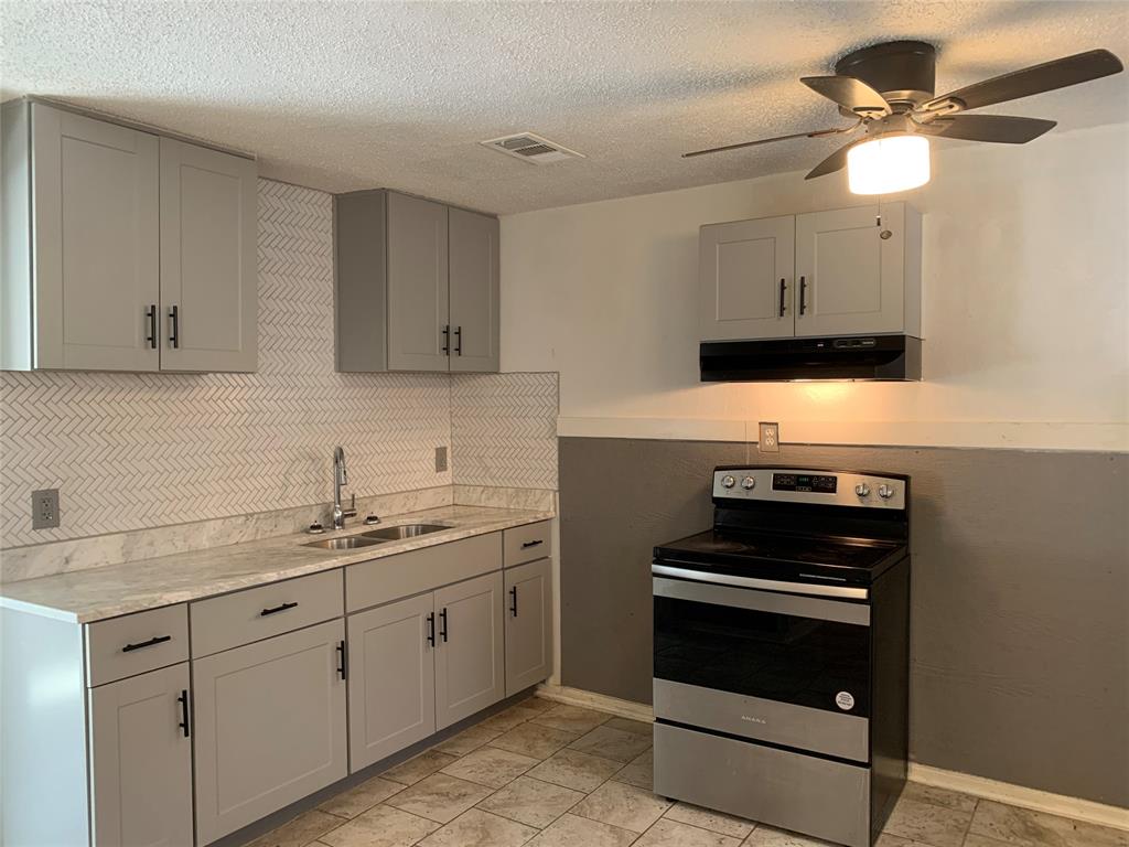 a kitchen with a sink stove and cabinets