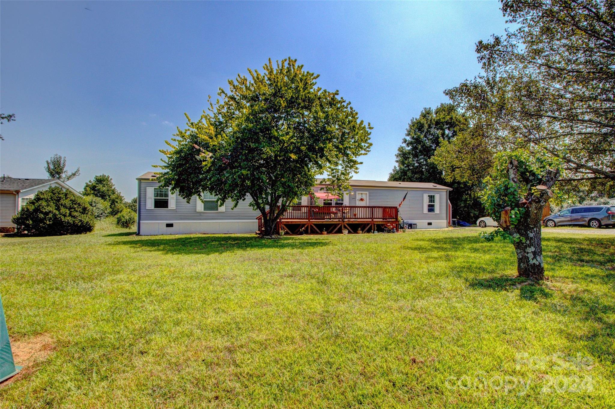 a front view of a house with a garden and trees