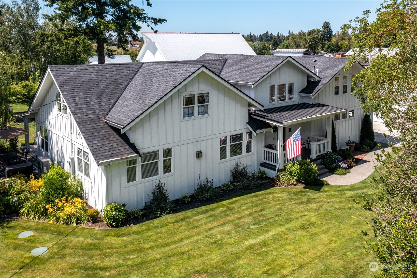 a aerial view of a house with yard and trees around