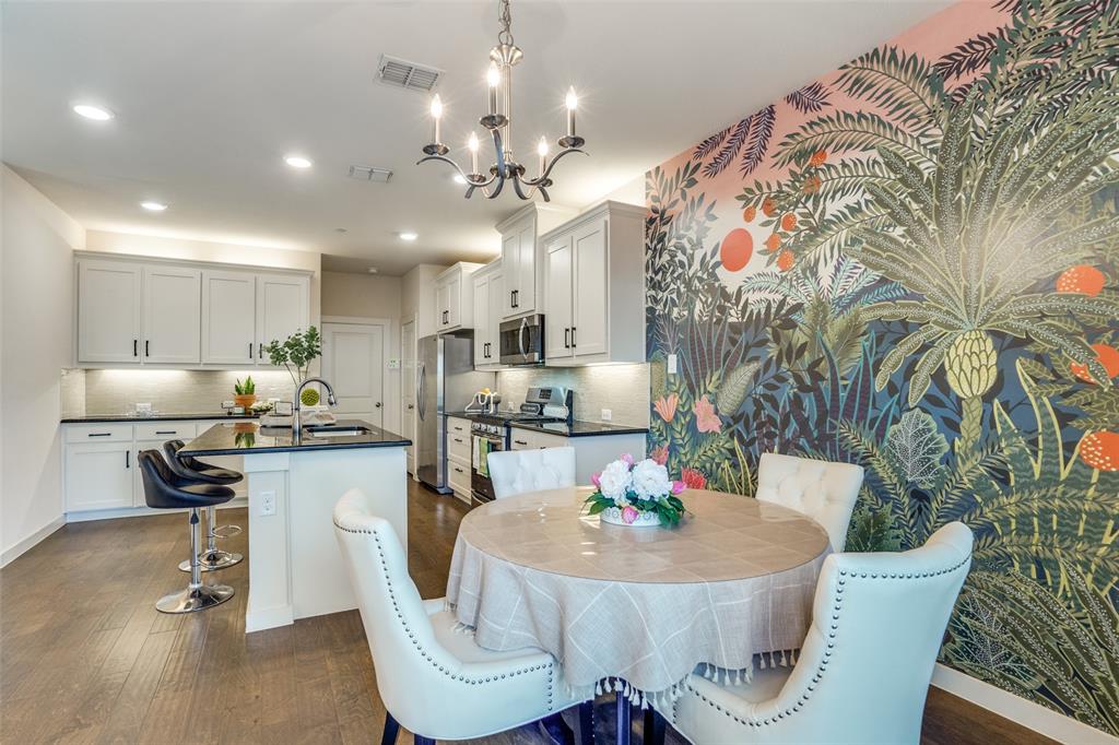 a kitchen with stainless steel appliances granite countertop a dining table chairs and a living room