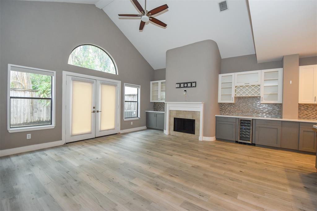 an empty room with windows fireplace and wooden floor