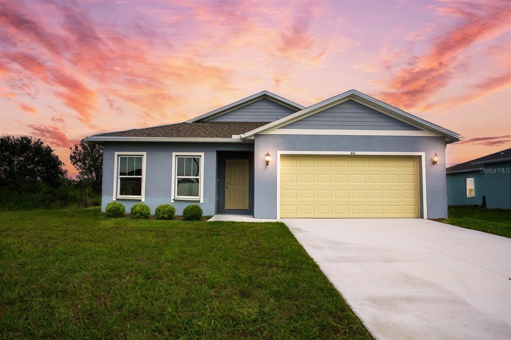 a front view of a house with yard and garage