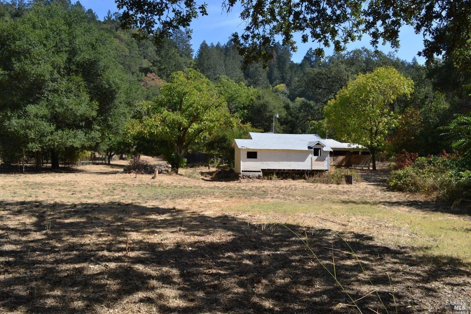 a view of a yard with wooden fence