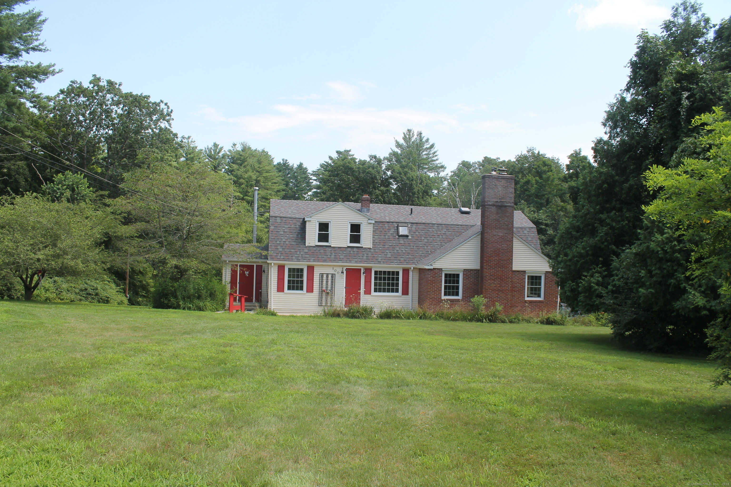 a view of a house with a big yard and large trees