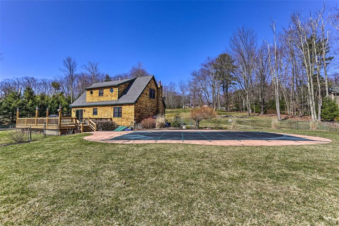 View of pool featuring a deck and a lawn