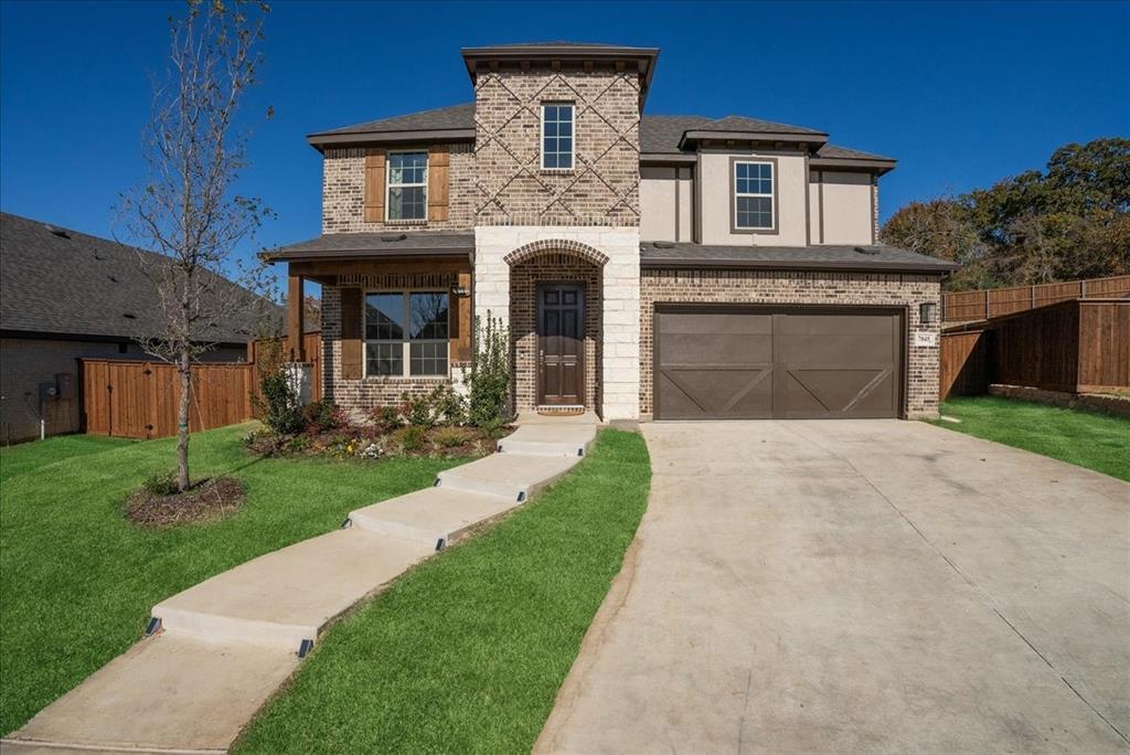 a front view of a house with a garden and yard