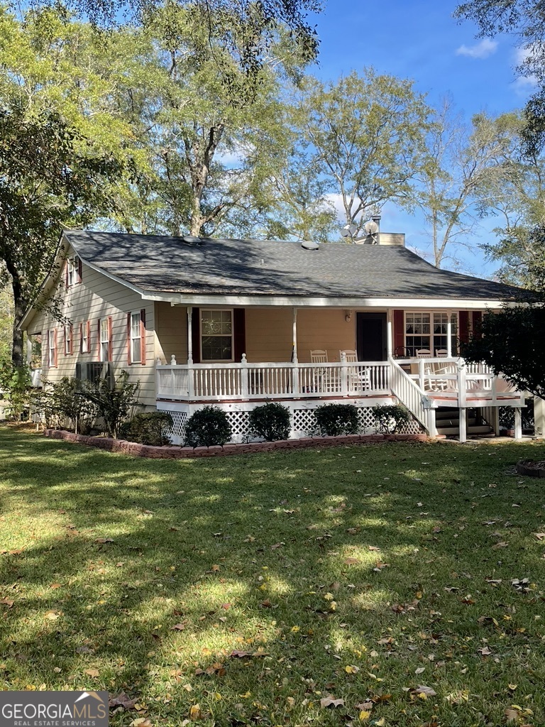 a front view of a house with a garden and trees