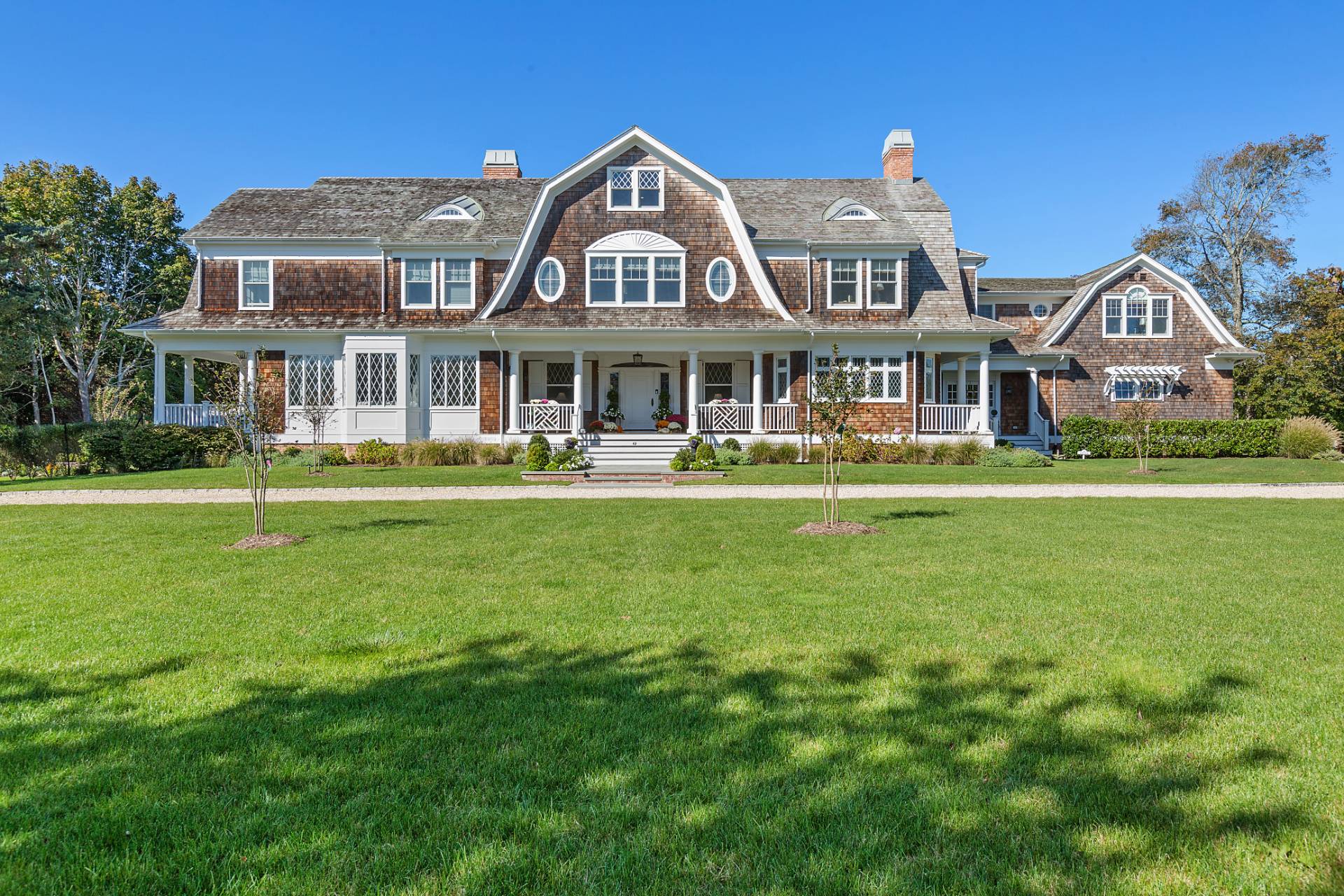 a front view of a house with a garden and trees