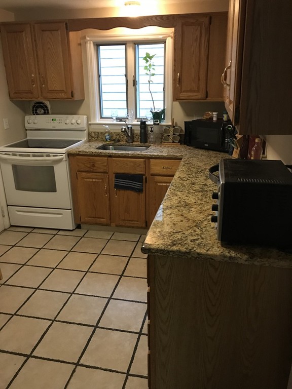 a kitchen with a sink a stove a counter top space and cabinets