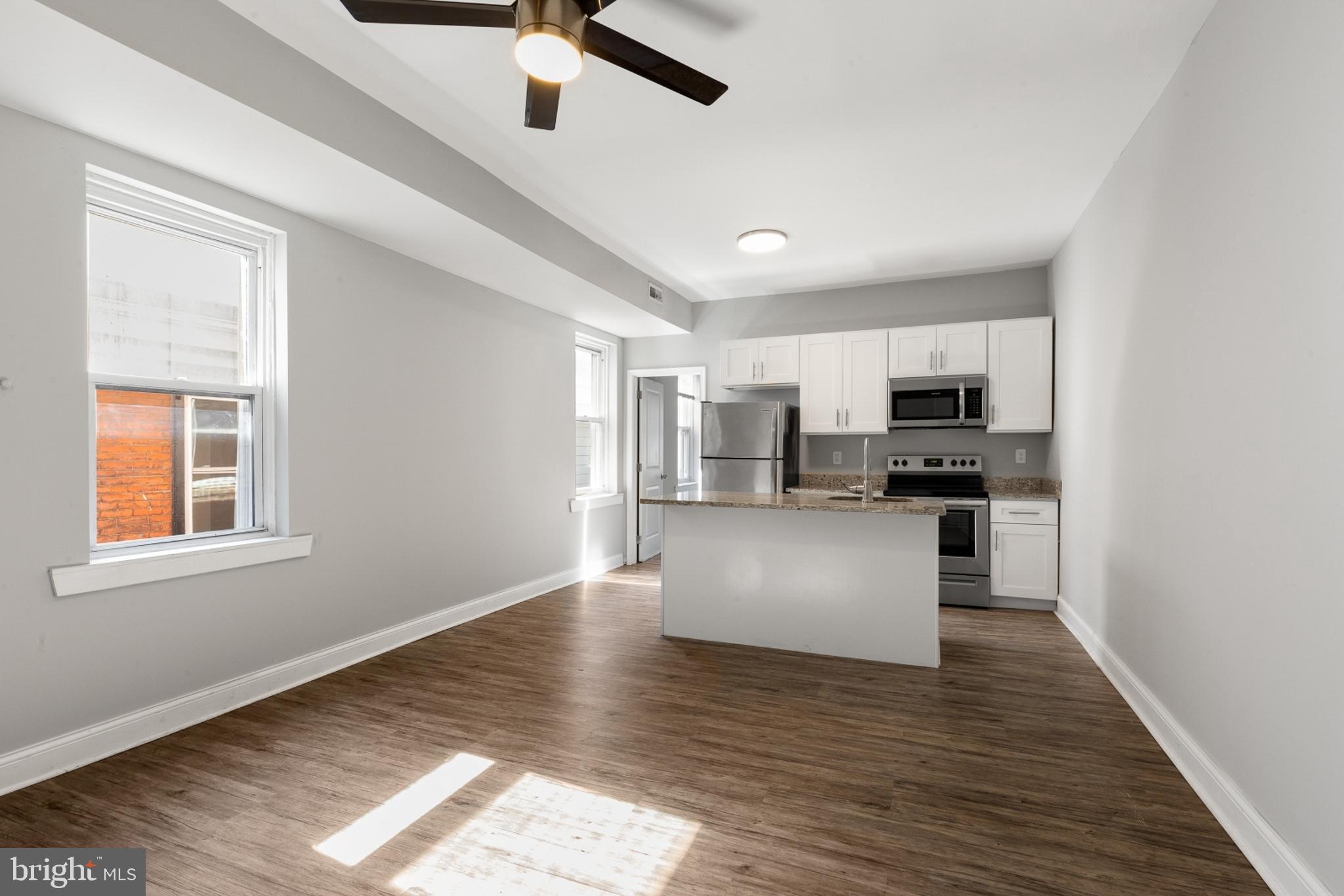 a view of kitchen with stainless steel appliances refrigerator stove microwave and cabinets