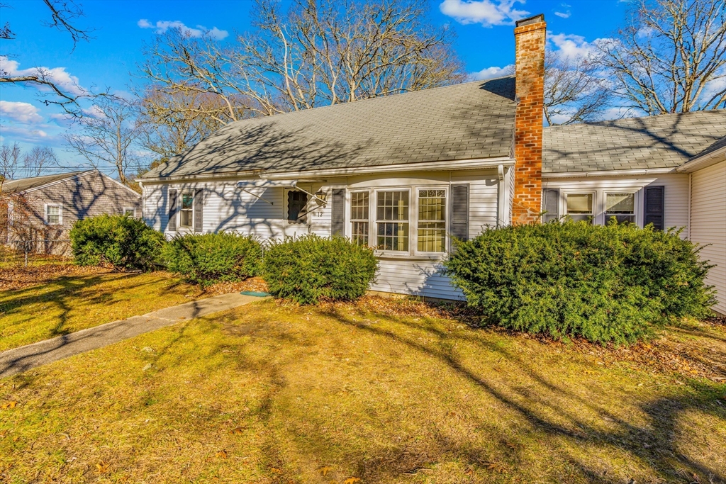 a front view of a house with a yard and trees