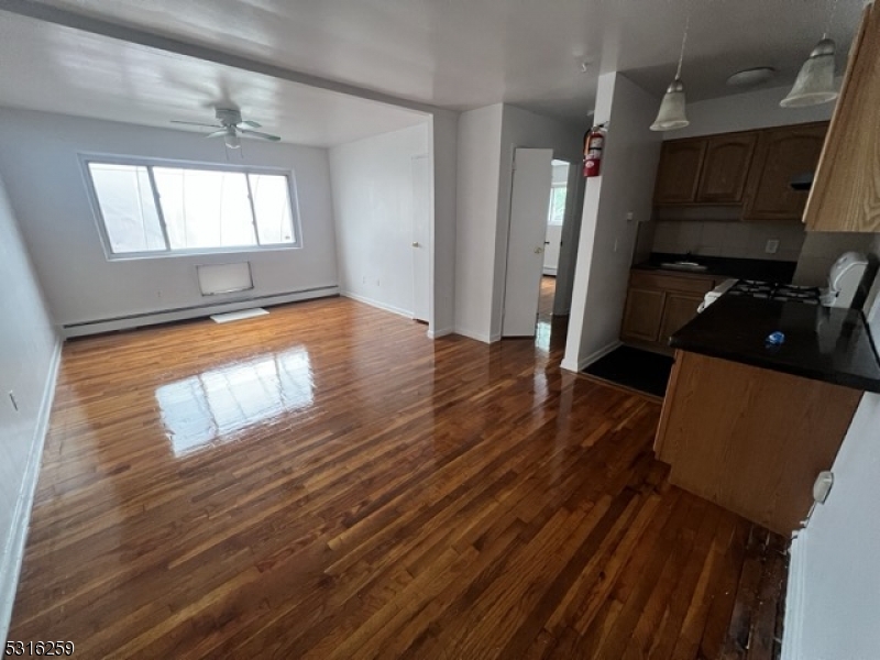 a view of empty room with wooden floor