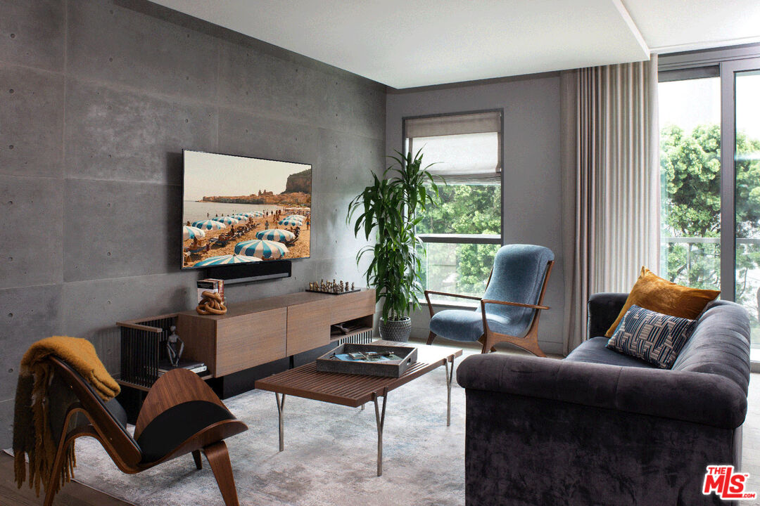 a living room with furniture a window and a flat screen tv