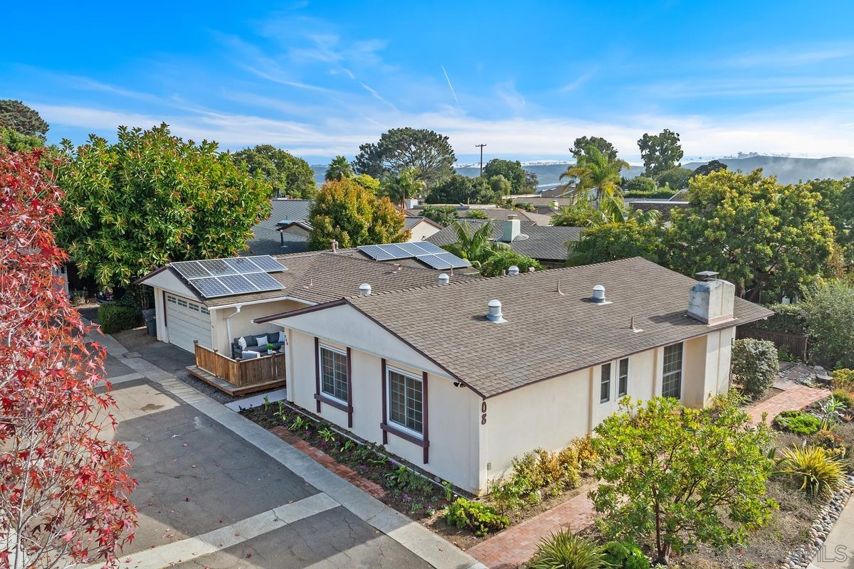 an aerial view of a house with a yard and large tree