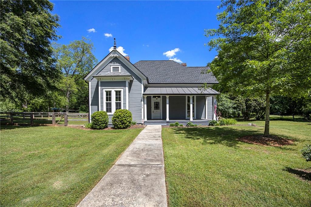 a front view of a house with a yard and trees