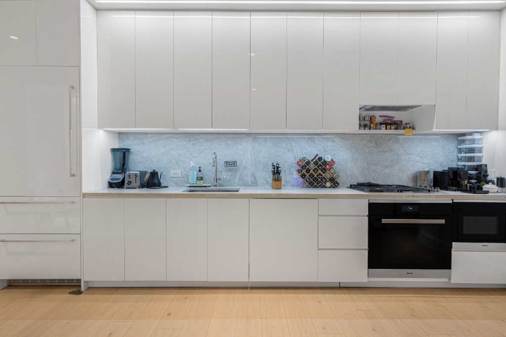 a kitchen with granite countertop white cabinets and white appliances