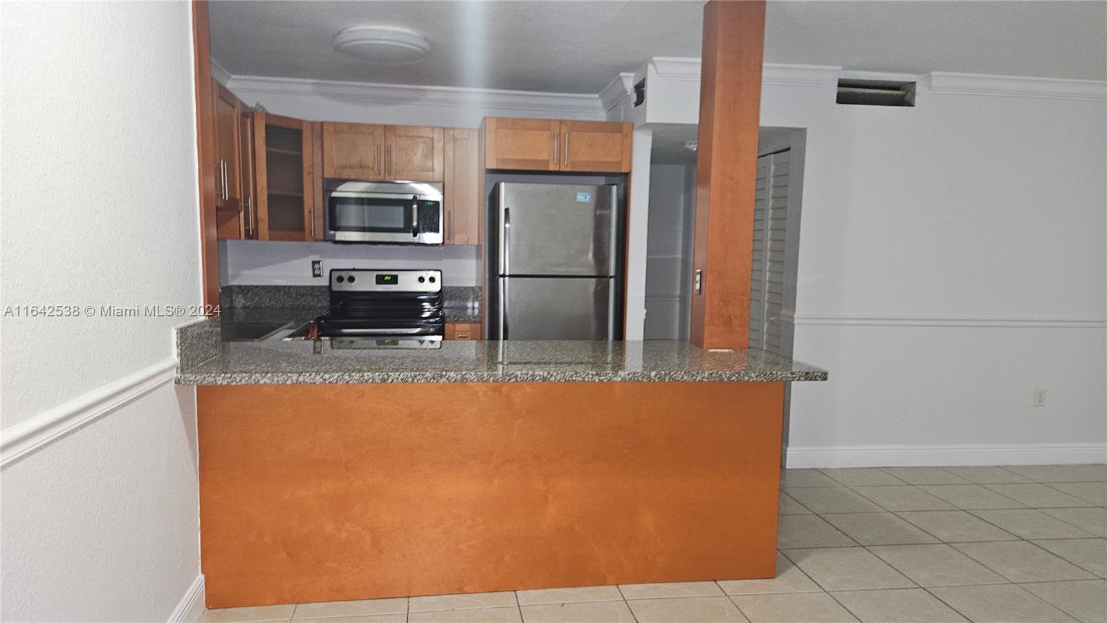 a large kitchen with stainless steel appliances a refrigerator and a stove