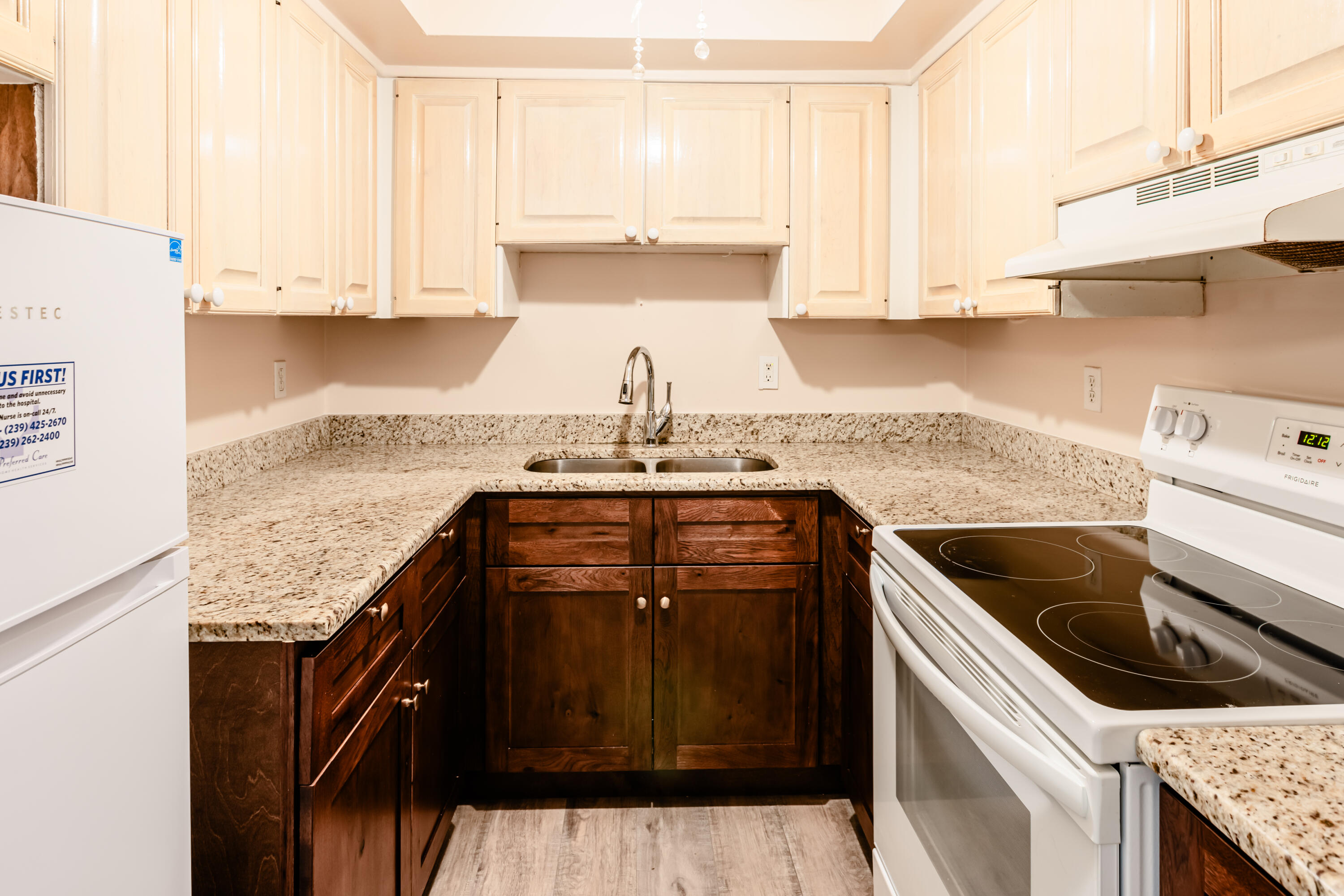 a kitchen with granite countertop a sink a stove and cabinets