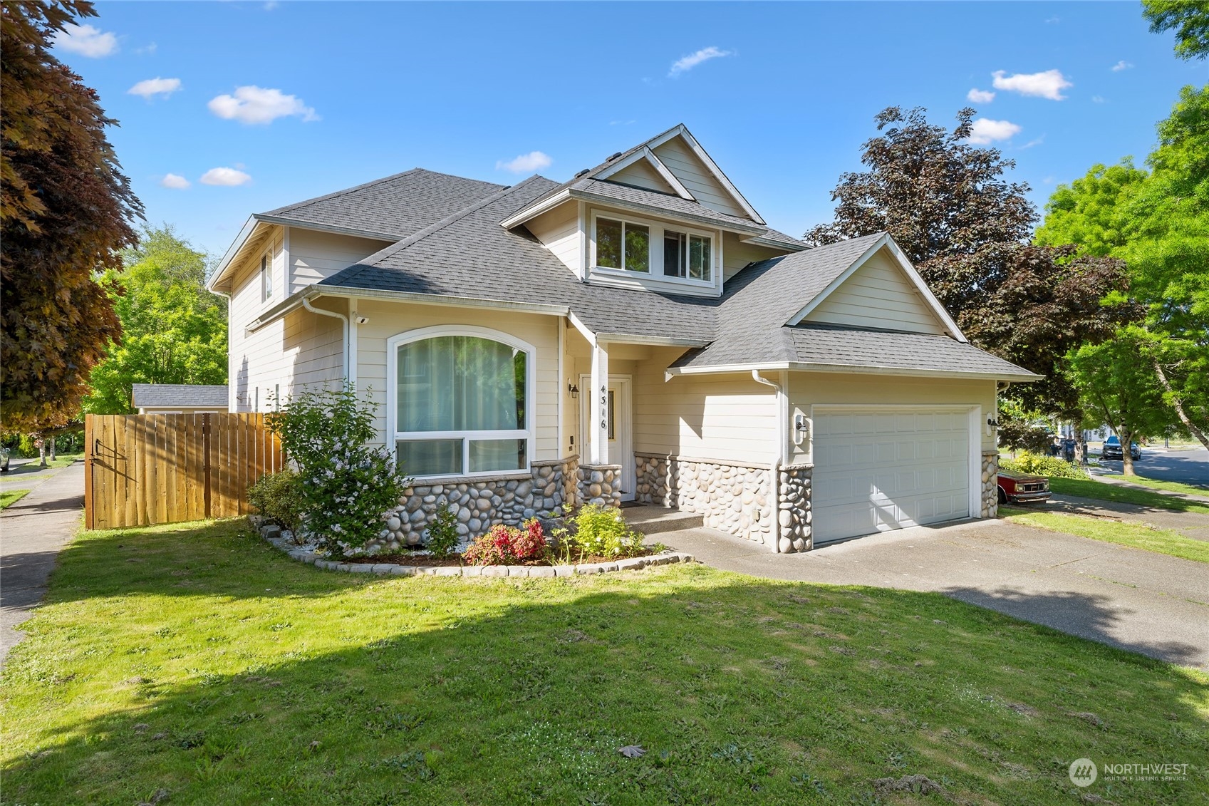 a front view of a house with a yard and trees