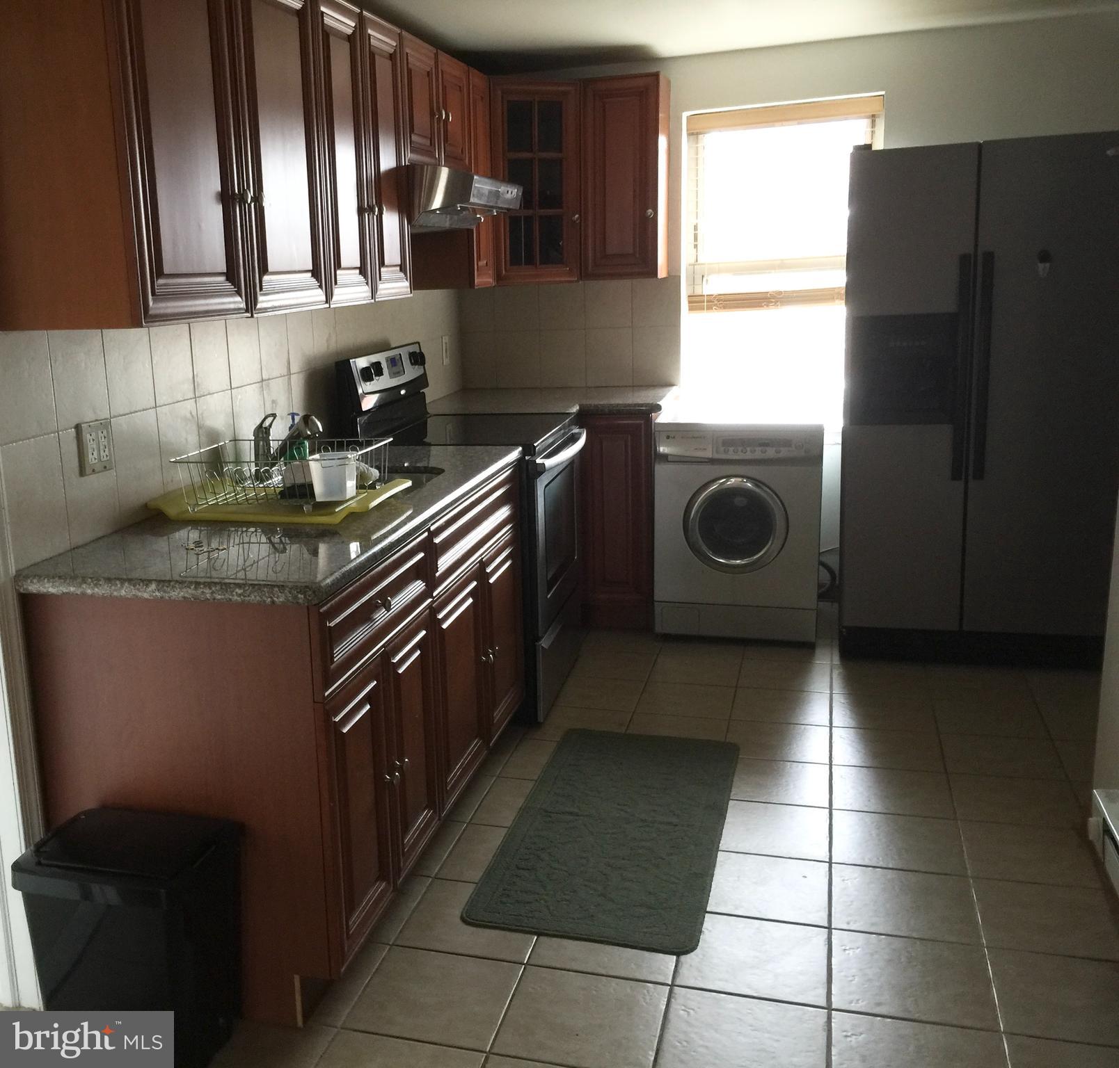 a kitchen with a stove a refrigerator and cabinets