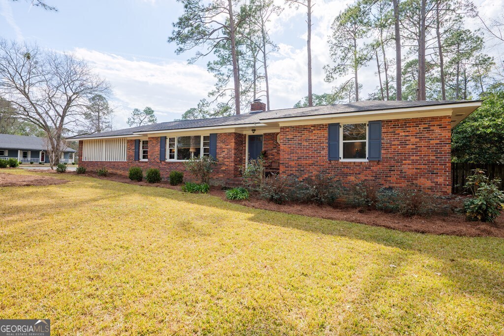 a front view of house with yard and trees around