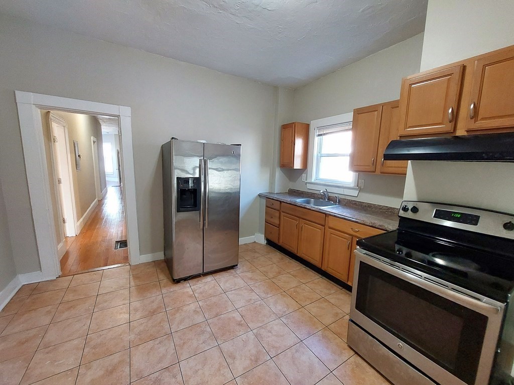 a kitchen with stainless steel appliances granite countertop a stove a sink and a refrigerator