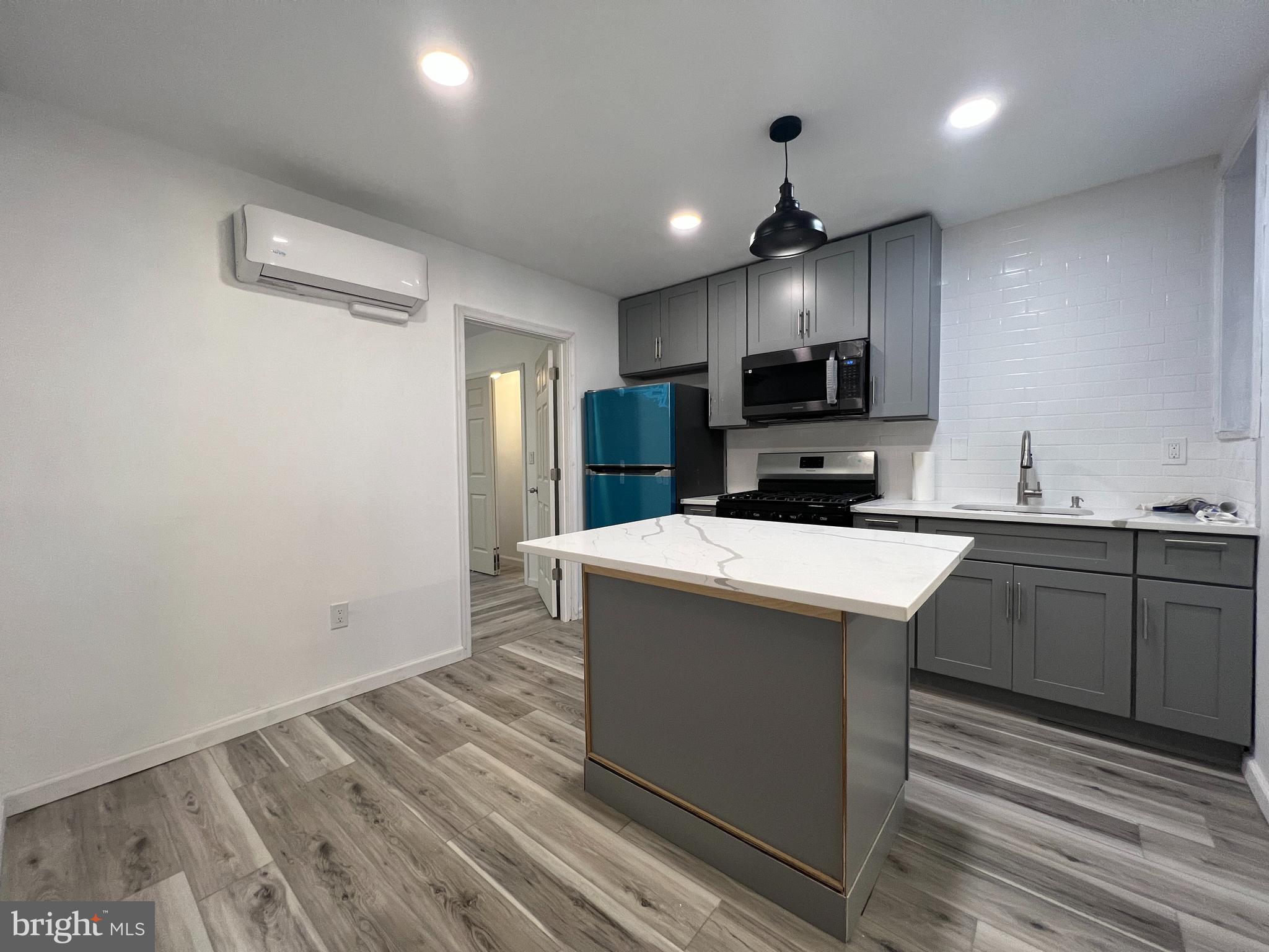 a kitchen with kitchen island a sink stainless steel appliances and cabinets