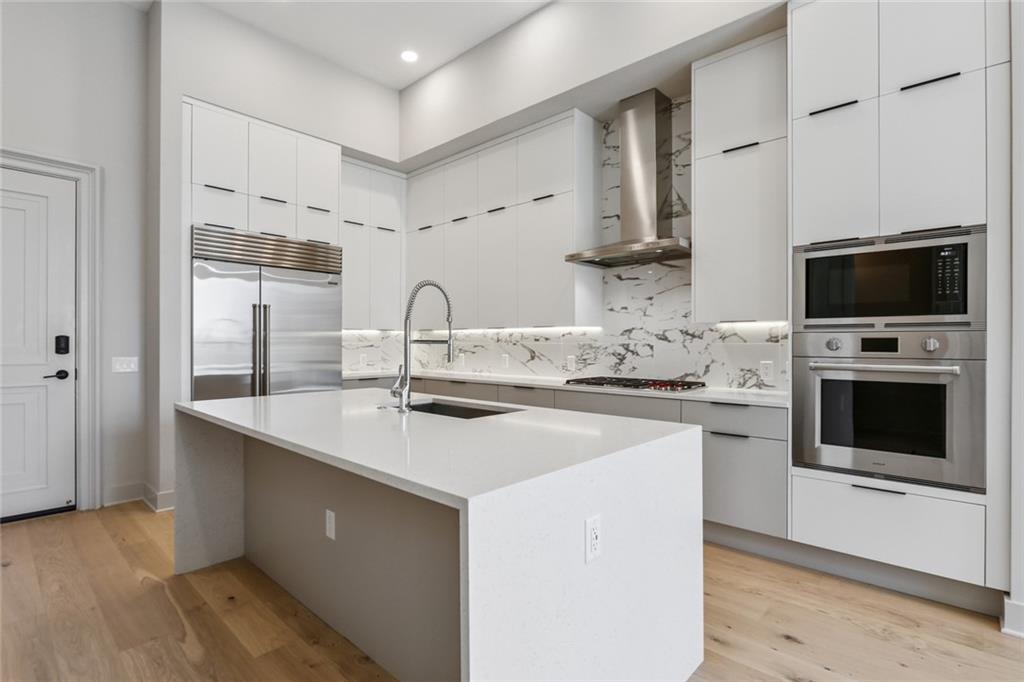 a kitchen with stainless steel appliances a stove microwave and cabinets