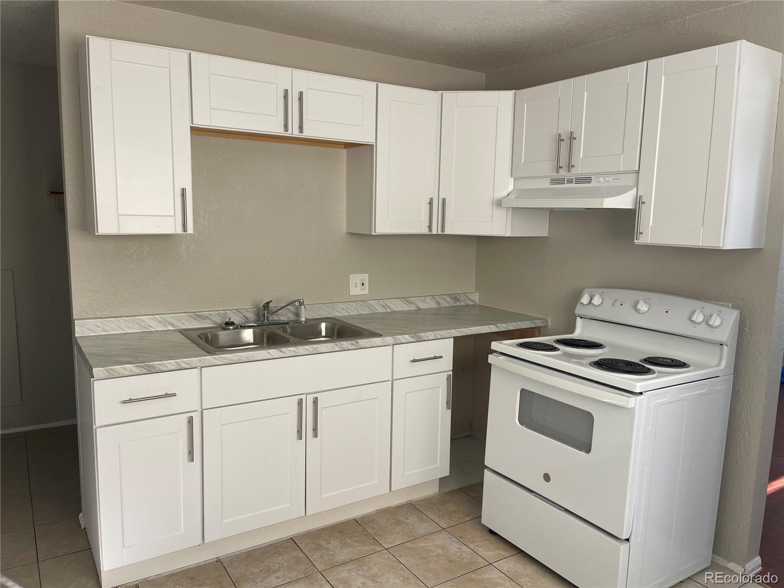 a kitchen with white cabinets and white appliances