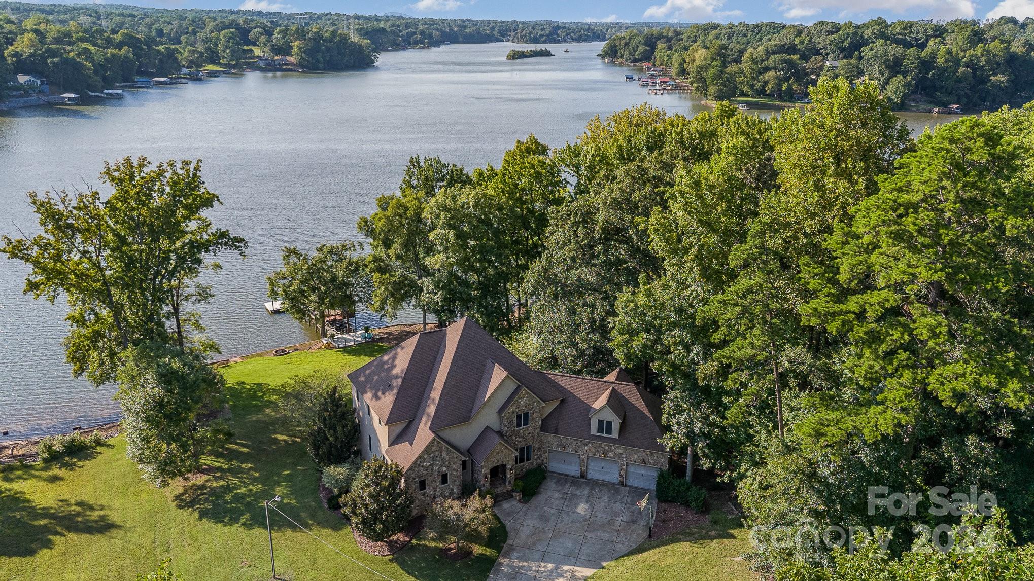 an aerial view of a house with a yard and lake view