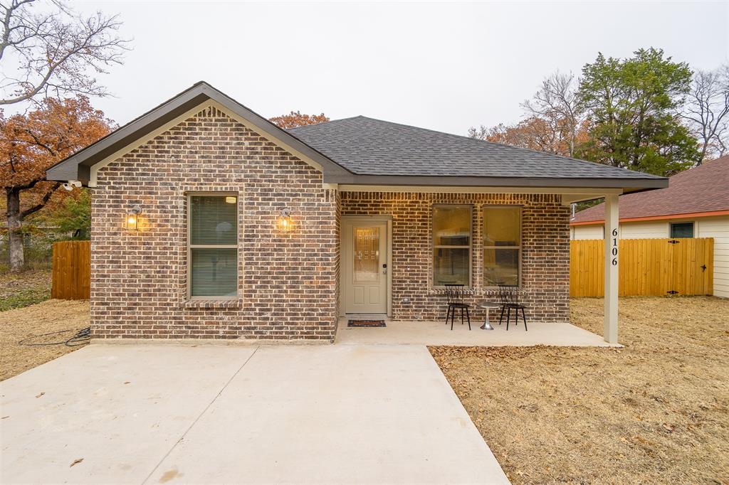 a front view of a house with a yard and seating space