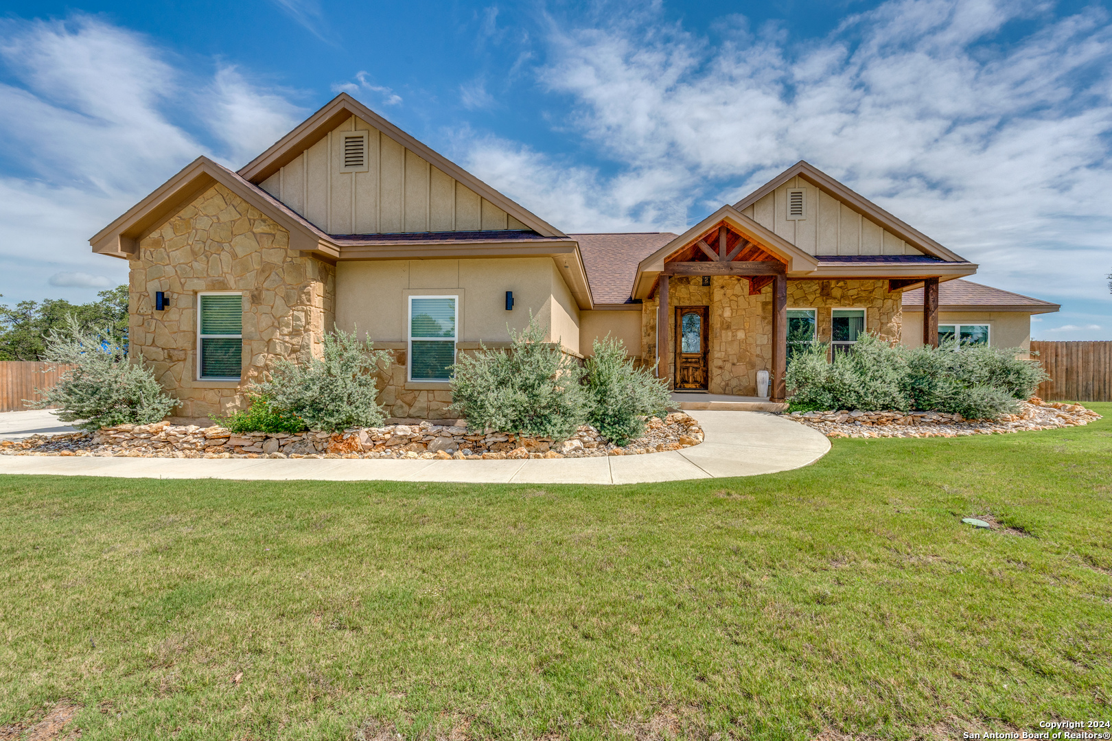 a front view of a house with yard and green space