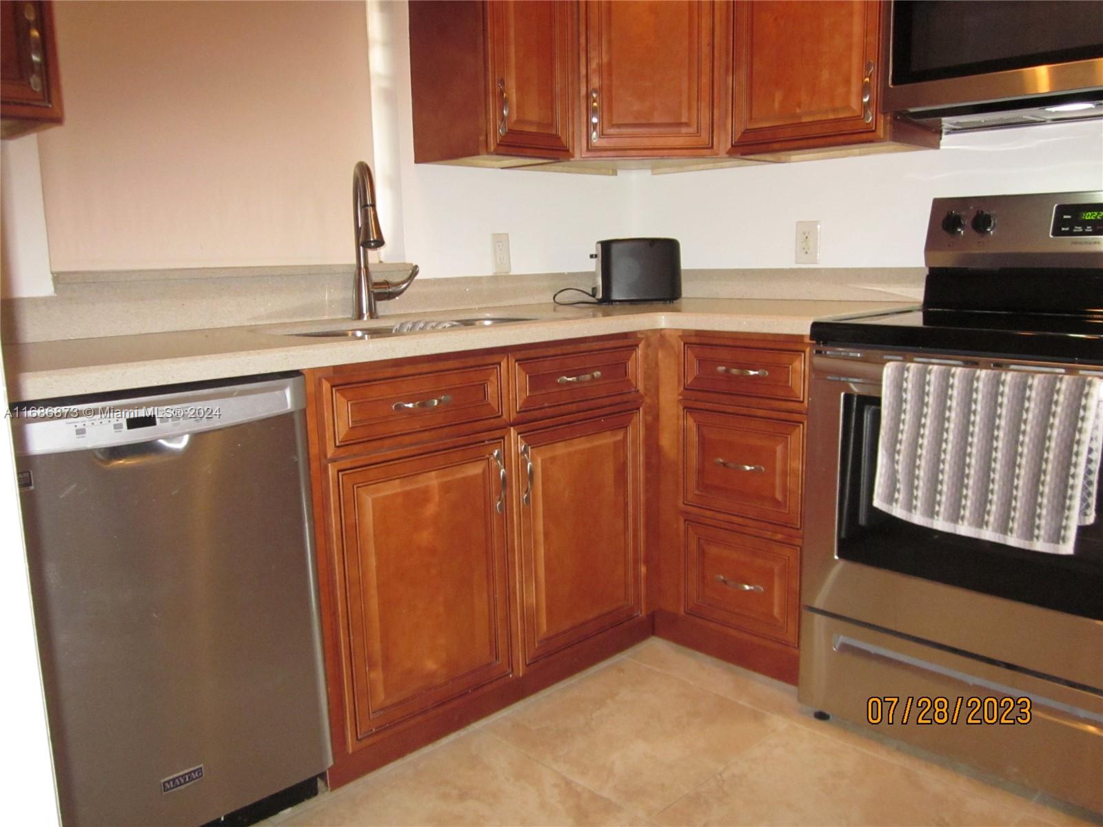 a kitchen with granite countertop cabinets and black appliances