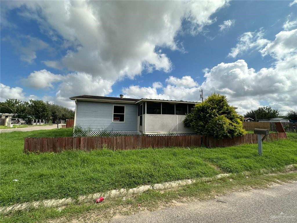 a view of yard with grass and a fence