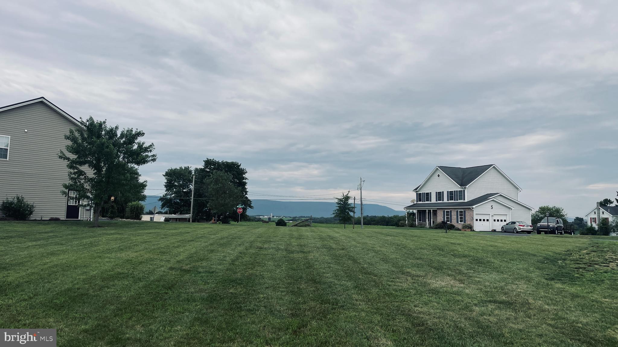 a view of a green field with house in the background