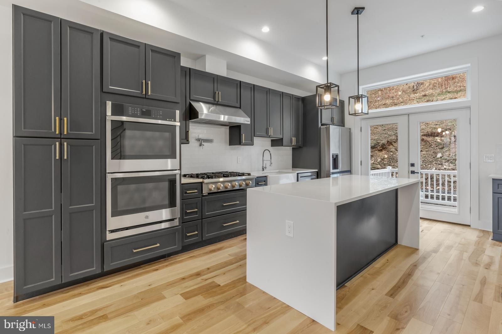 a kitchen with kitchen island a counter top space stainless steel appliances and a ceiling fan