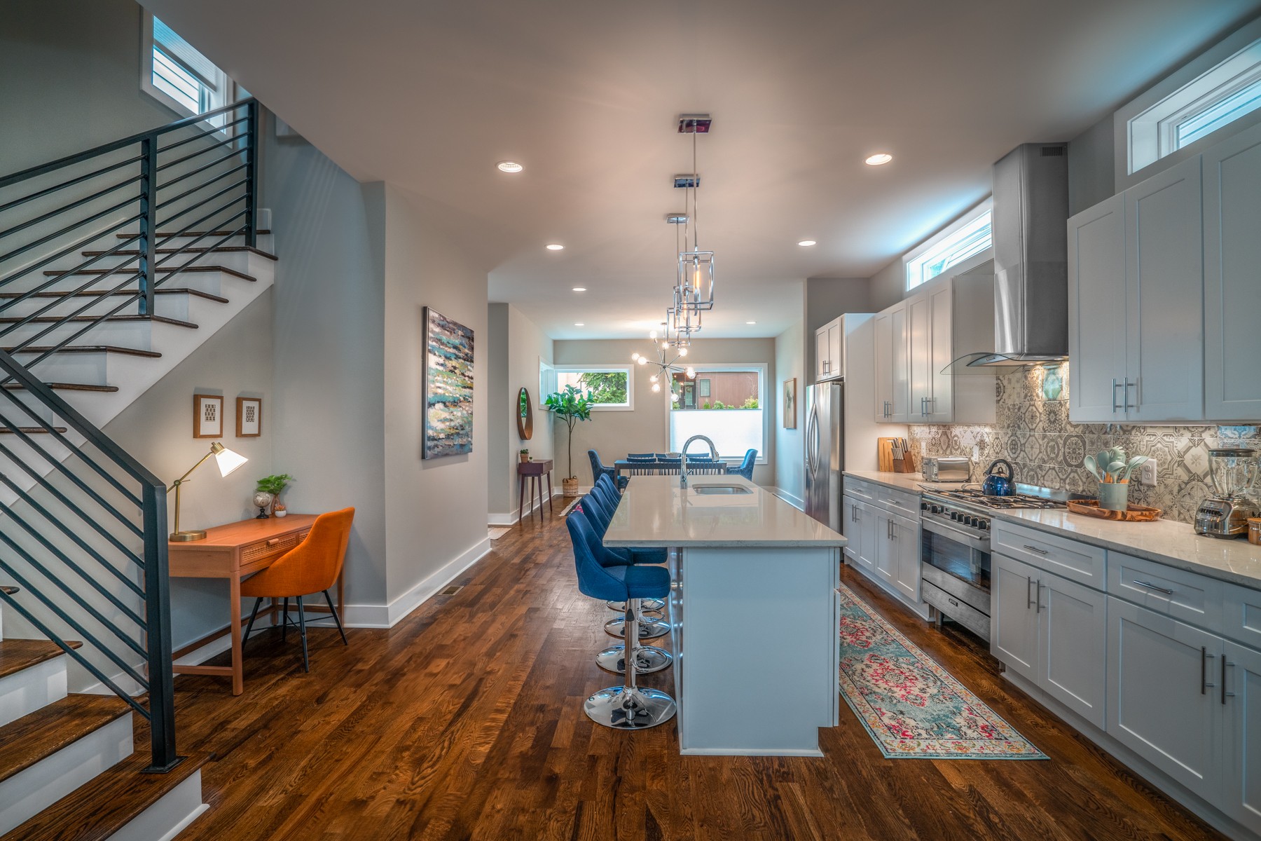 a kitchen with stainless steel appliances kitchen island granite countertop a table chairs in it and a wooden floors