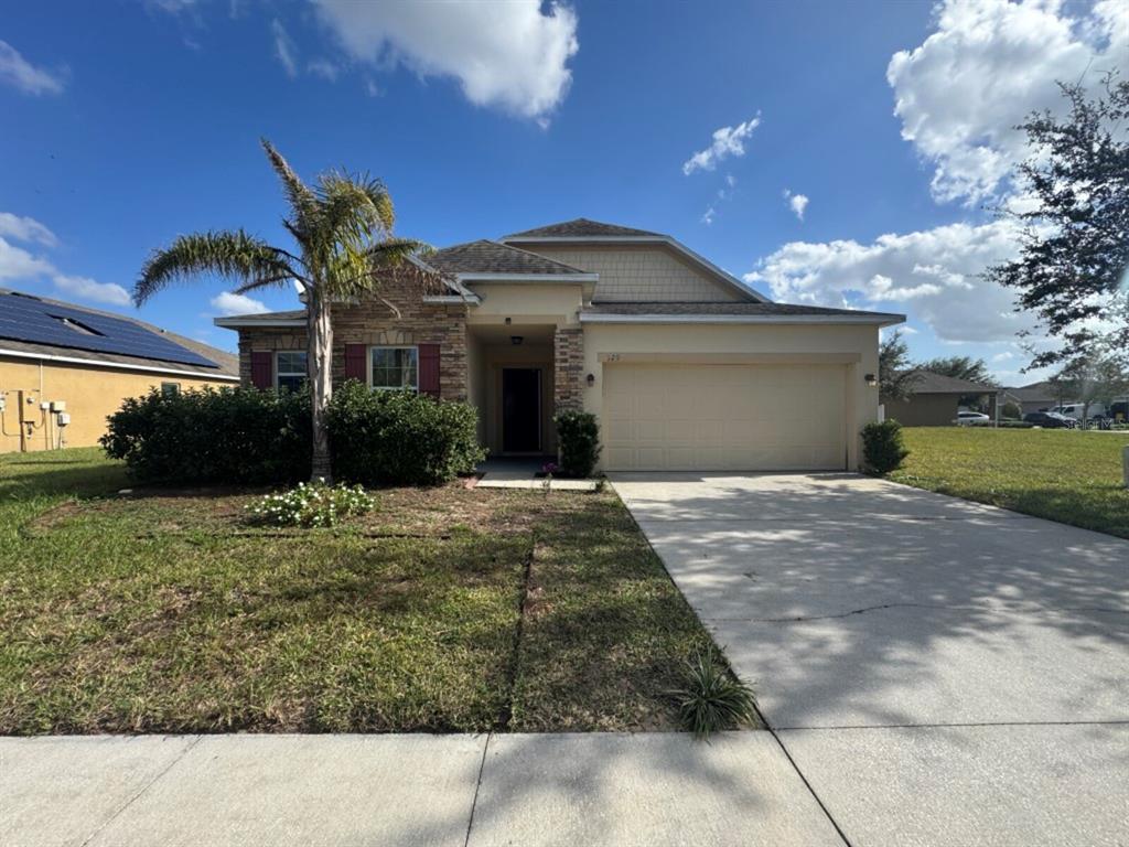 a front view of a house with a yard and a garage