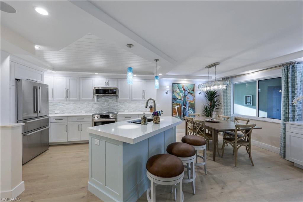 a kitchen with refrigerator and chairs