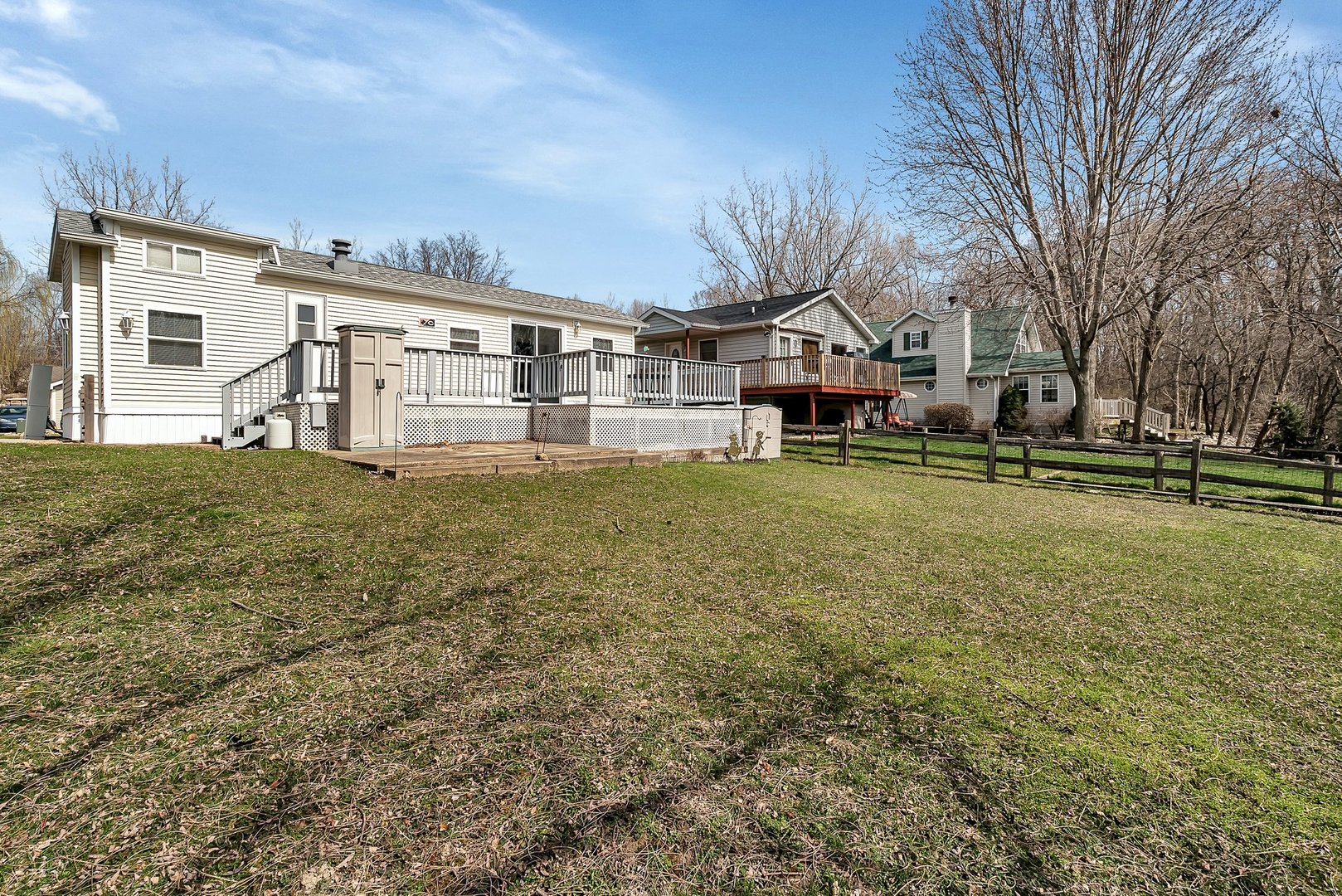 a view of a big house with a big yard and large trees