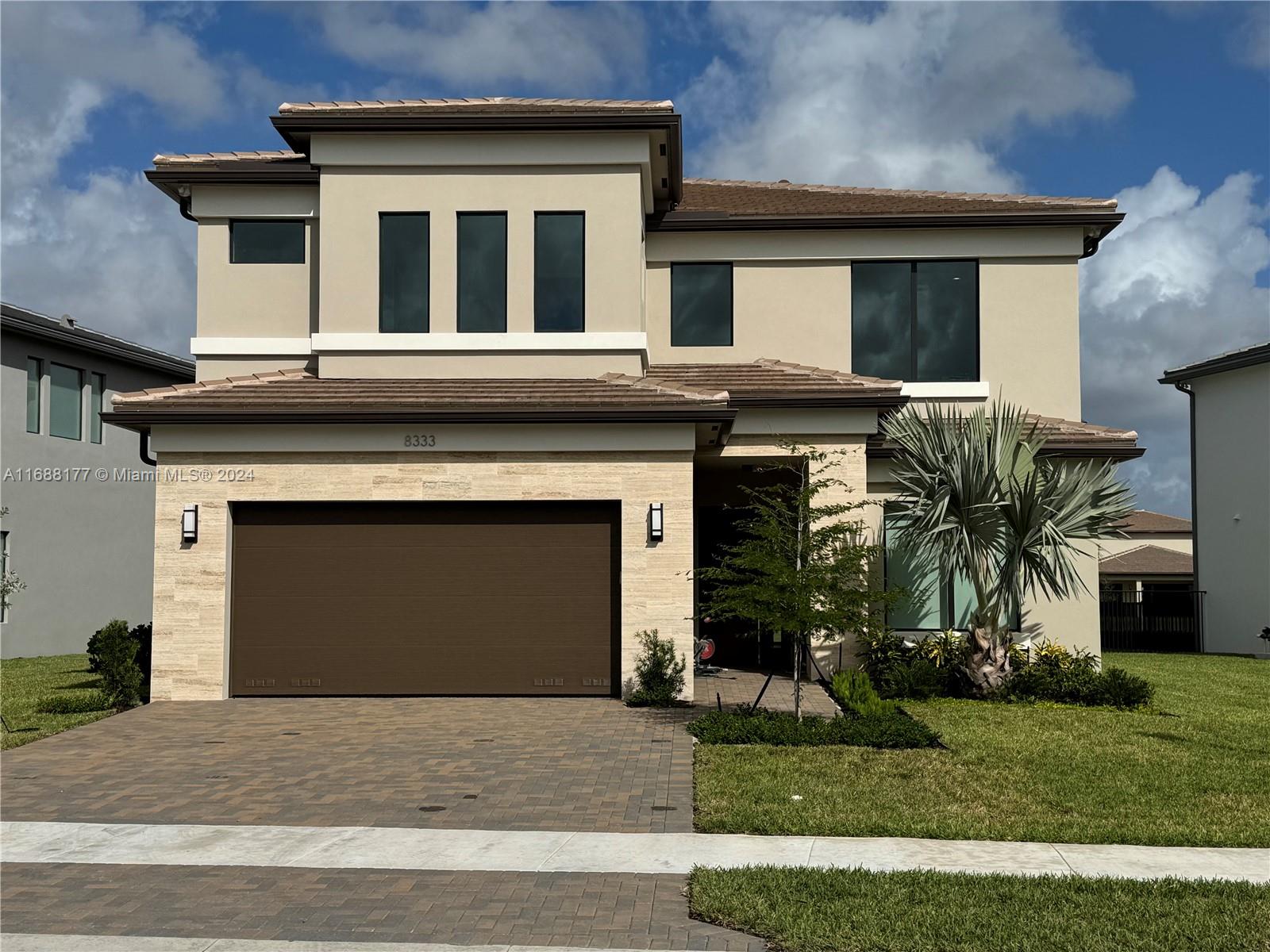 a front view of a house with a garden and garage