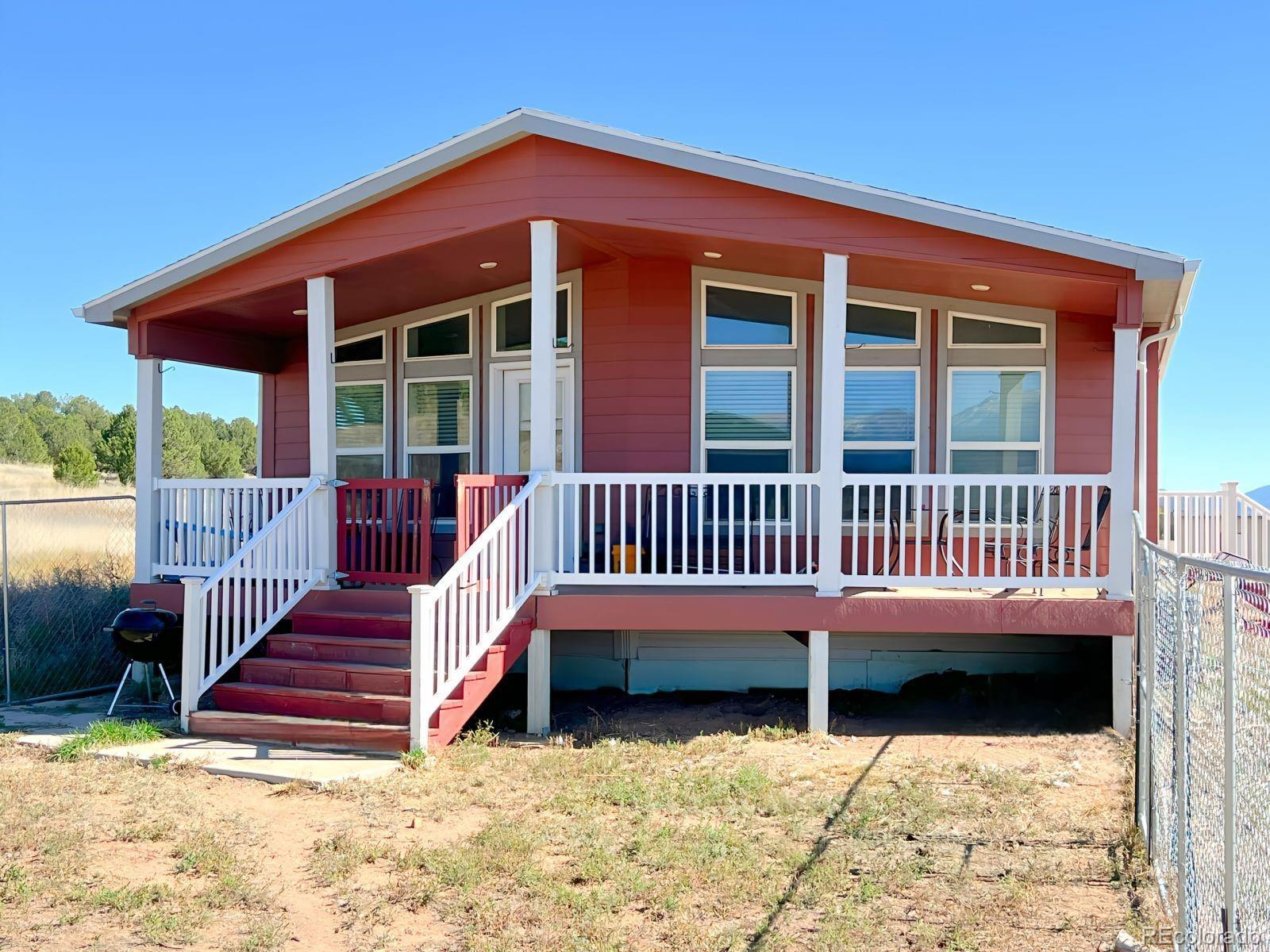 a view of a house with wooden deck and a yard