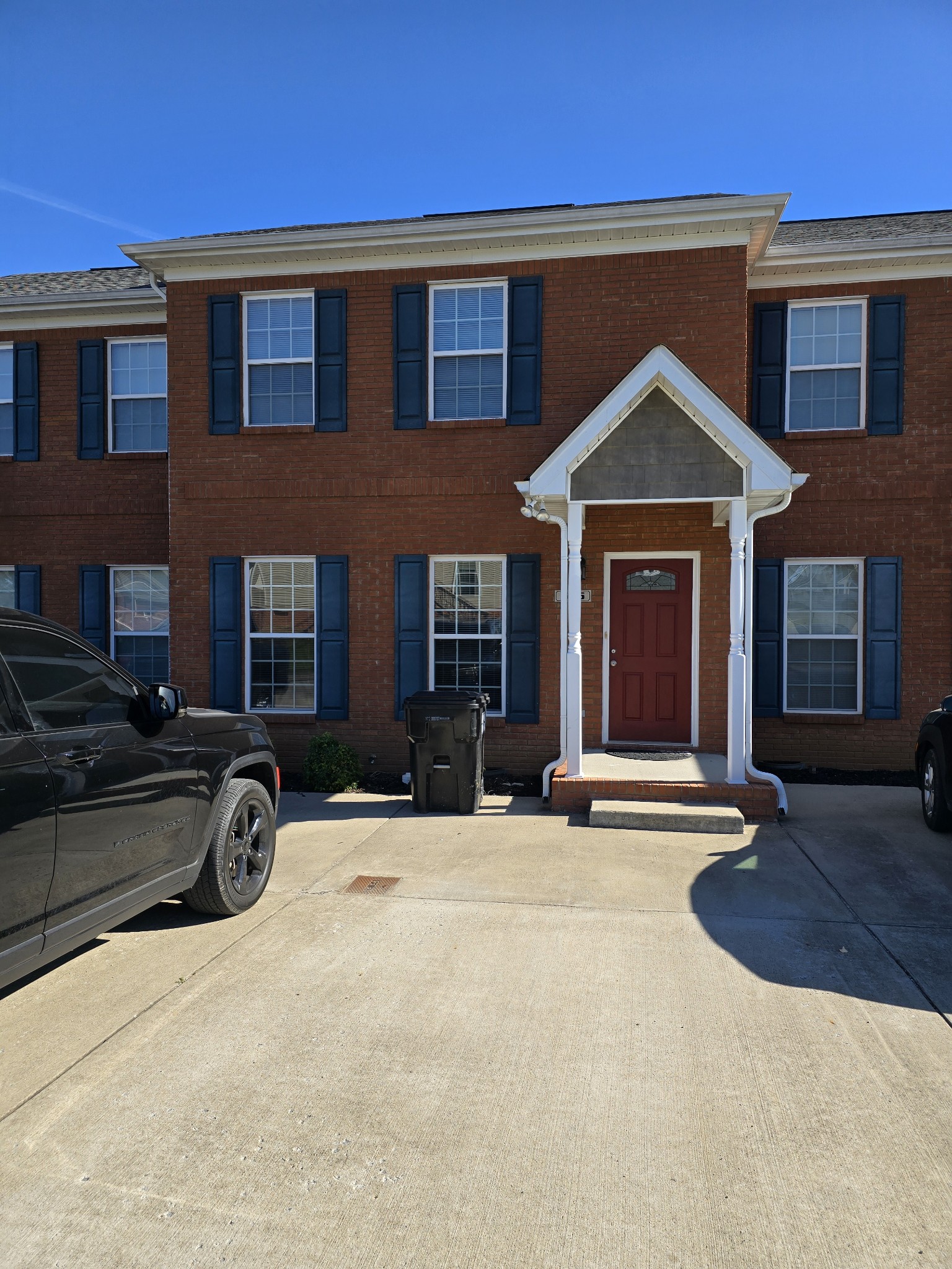 a view of a brick house with a yard in front of it